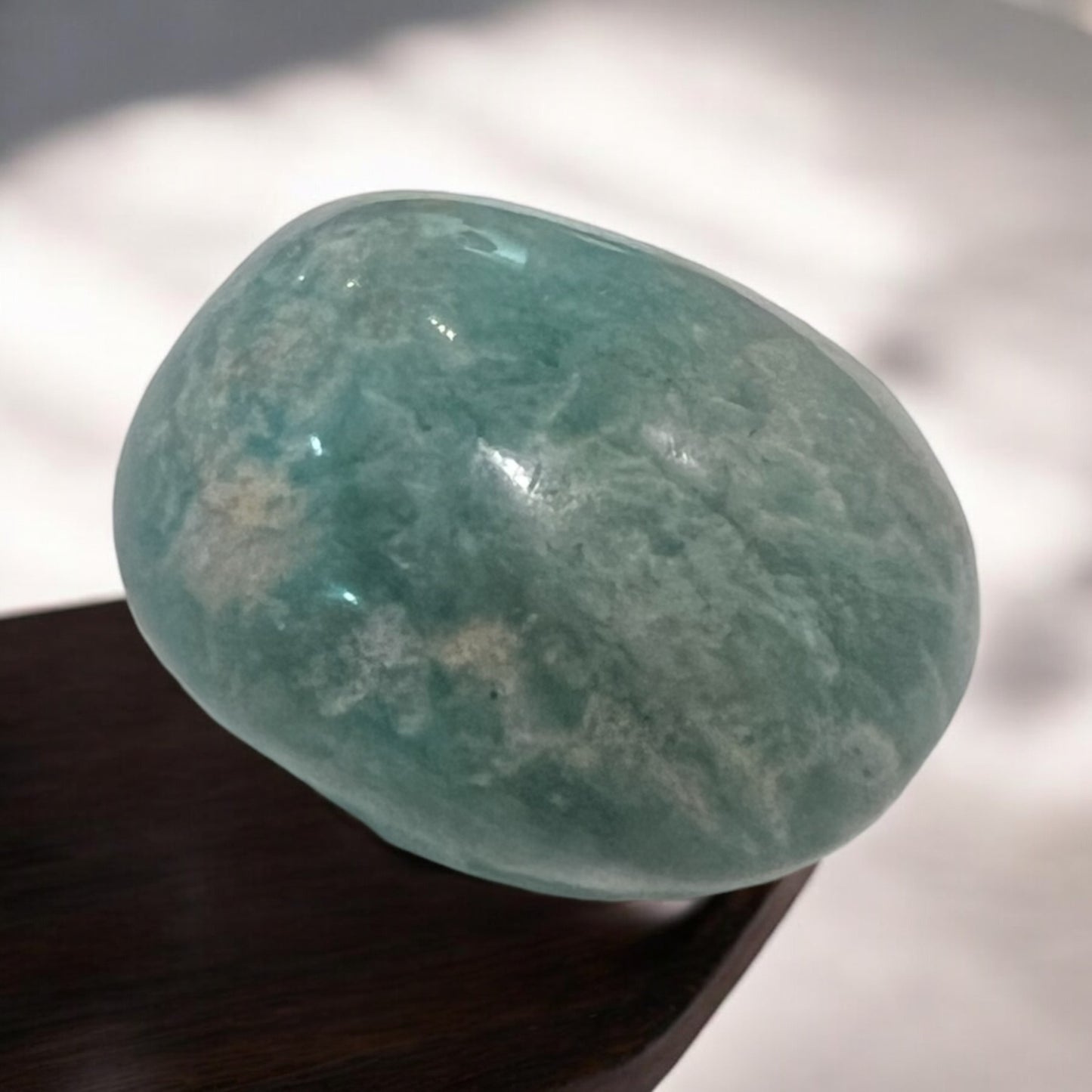 A beautifully polished Amazonite palm stone, ergonomically shaped for easy holding, showcasing calming blue-green colours and smooth textures that promote relaxation and emotional stability.