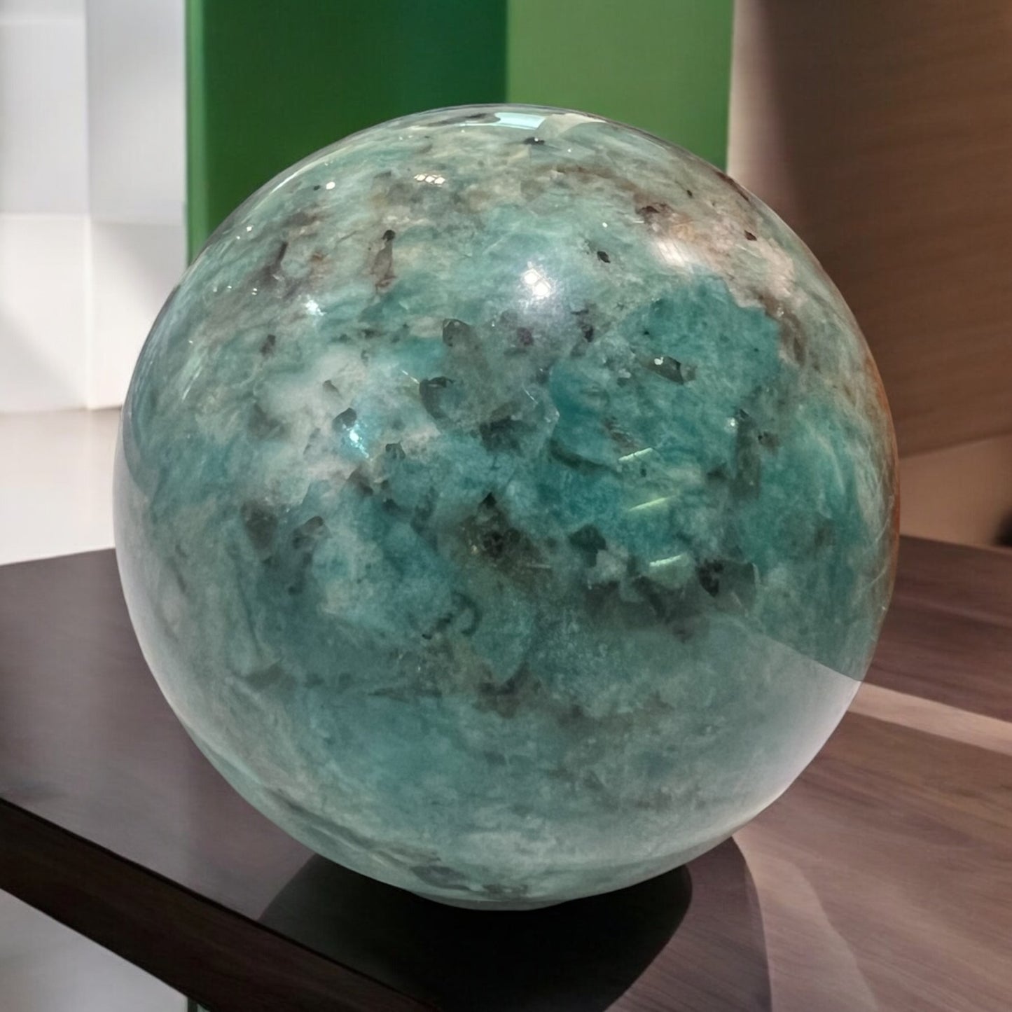 A polished crystal sphere, showcasing vibrant blue-green colours and unique natural patterns, representing unity and clarity while promoting positive energy